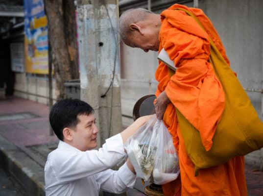 อาจารย์บารมี ขณะตักบาตร